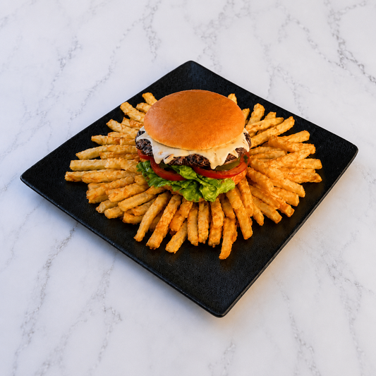 FactoryBeef Hamburger on a bed of fries on a black plate with a marble background